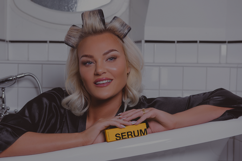 Girl with serum in her hand in a bathtub